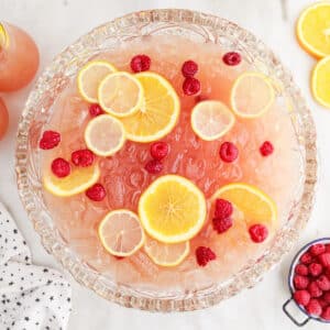 Top view of Party Punch Recipe showing the sliced lemons and berries inside the punch with other ingredients in the background.