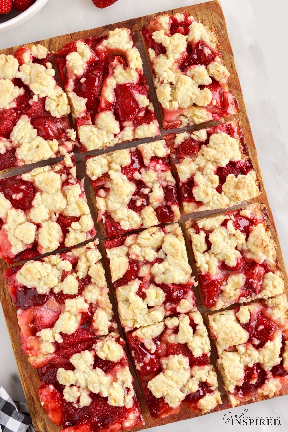 Cut Strawberry Bars in a baking dish on the counter.