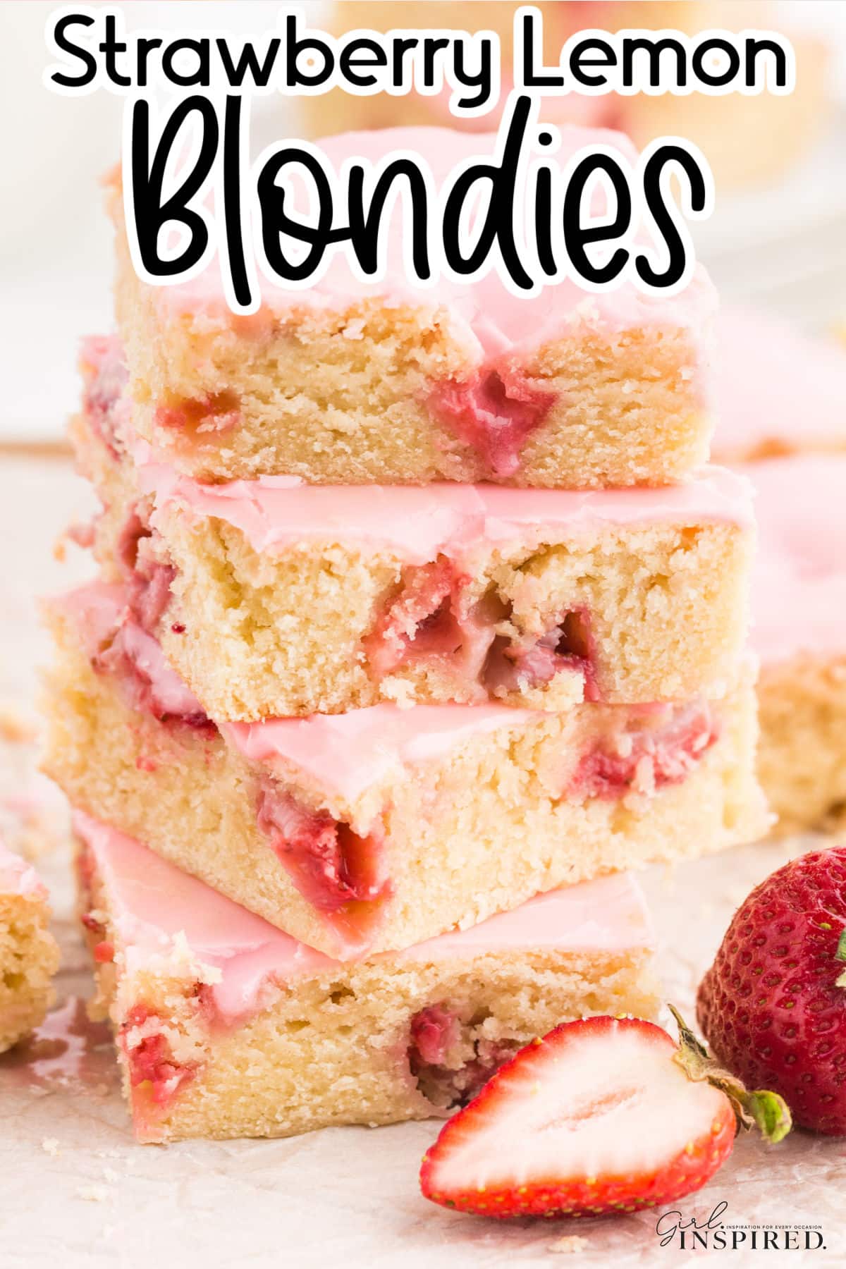 Tall stack of Strawberry Lemon Blondies on a plate showing the berries and brownie inside with pink frosting and text overlay.