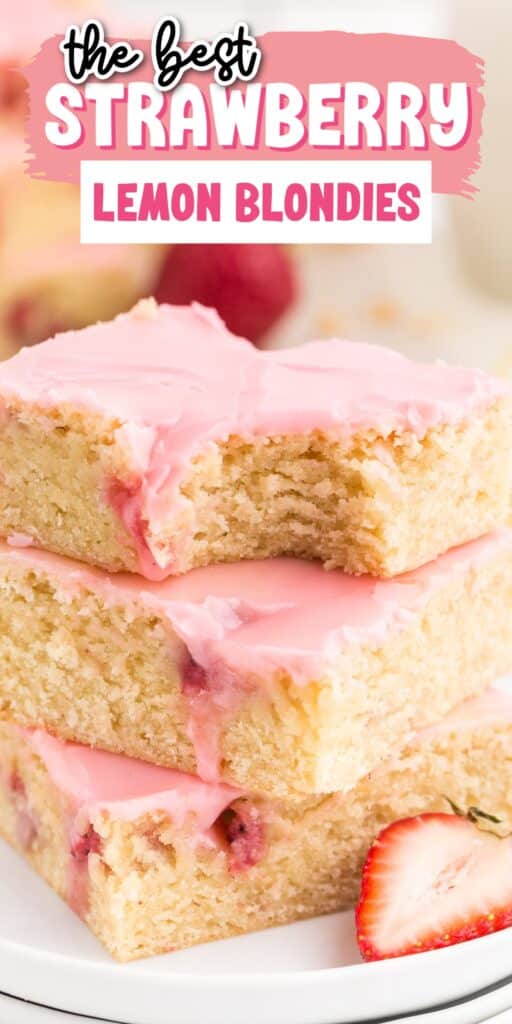 Tall stack of Strawberry Lemon Blondies on a plate showing the berries and brownie inside with pink frosting and a bite taken out of the top one.