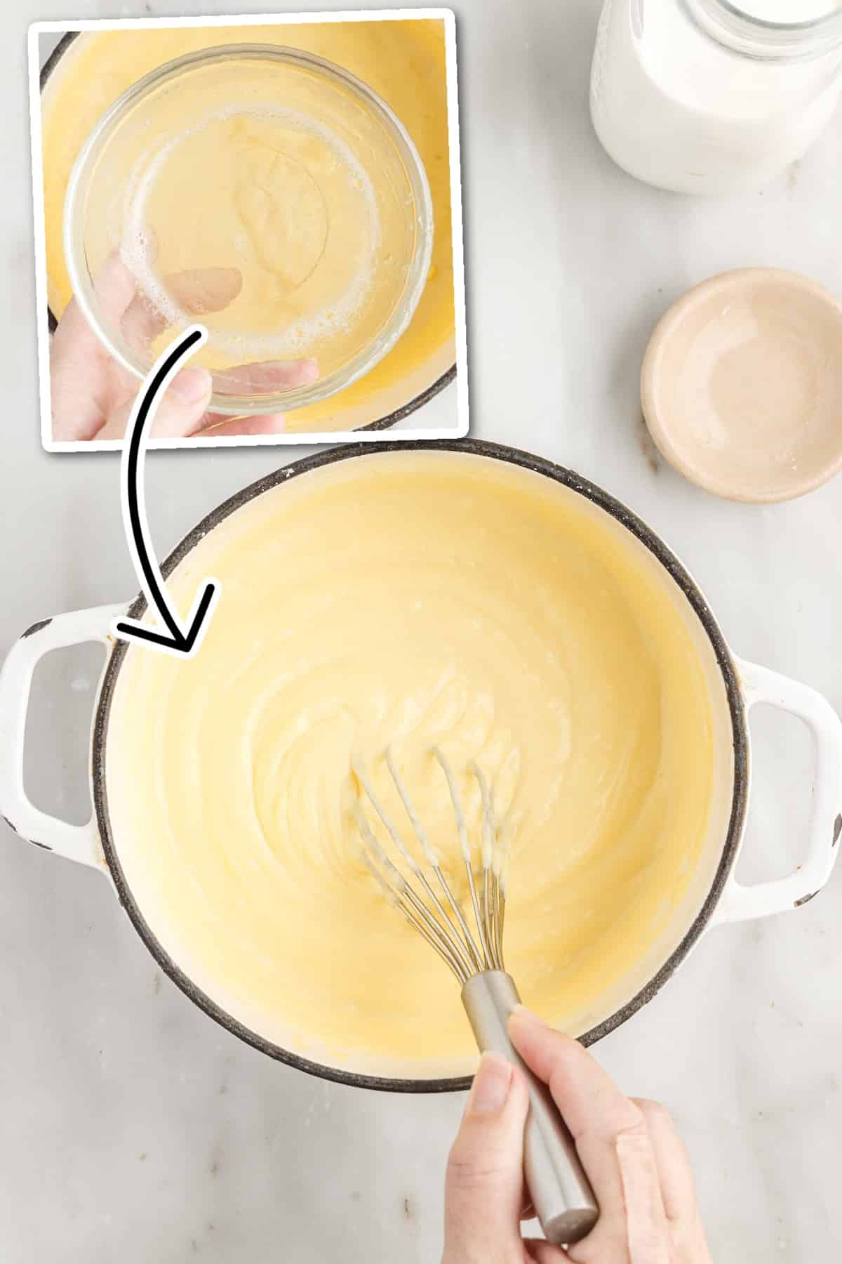 Overhead view of the pastry cream thickened mixture with whisk to mix in the gelatin mixture, vanilla extract and butter.