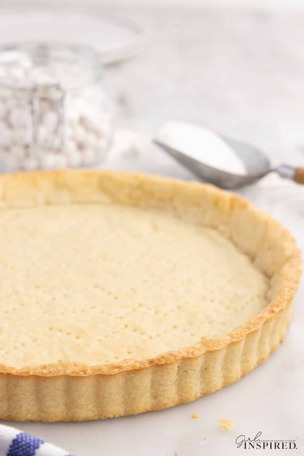 Close up side view of the baked pate sucree pastry shell that has been removed from the tart pan.