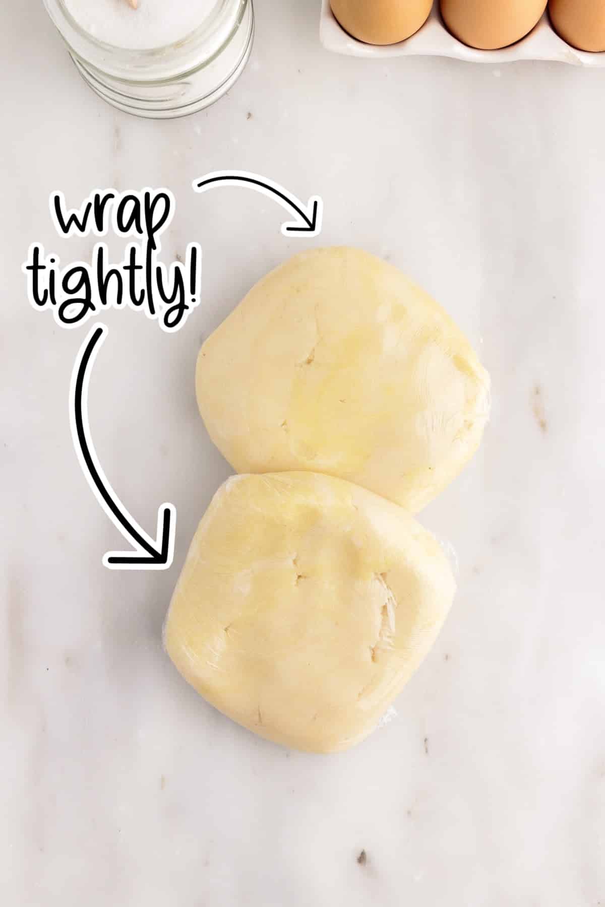 The two pieces of dough wrapped tightly in plastic wrap.