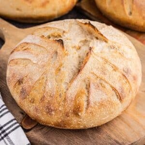 A round loaf of basic sourdough bread on a cutting board.