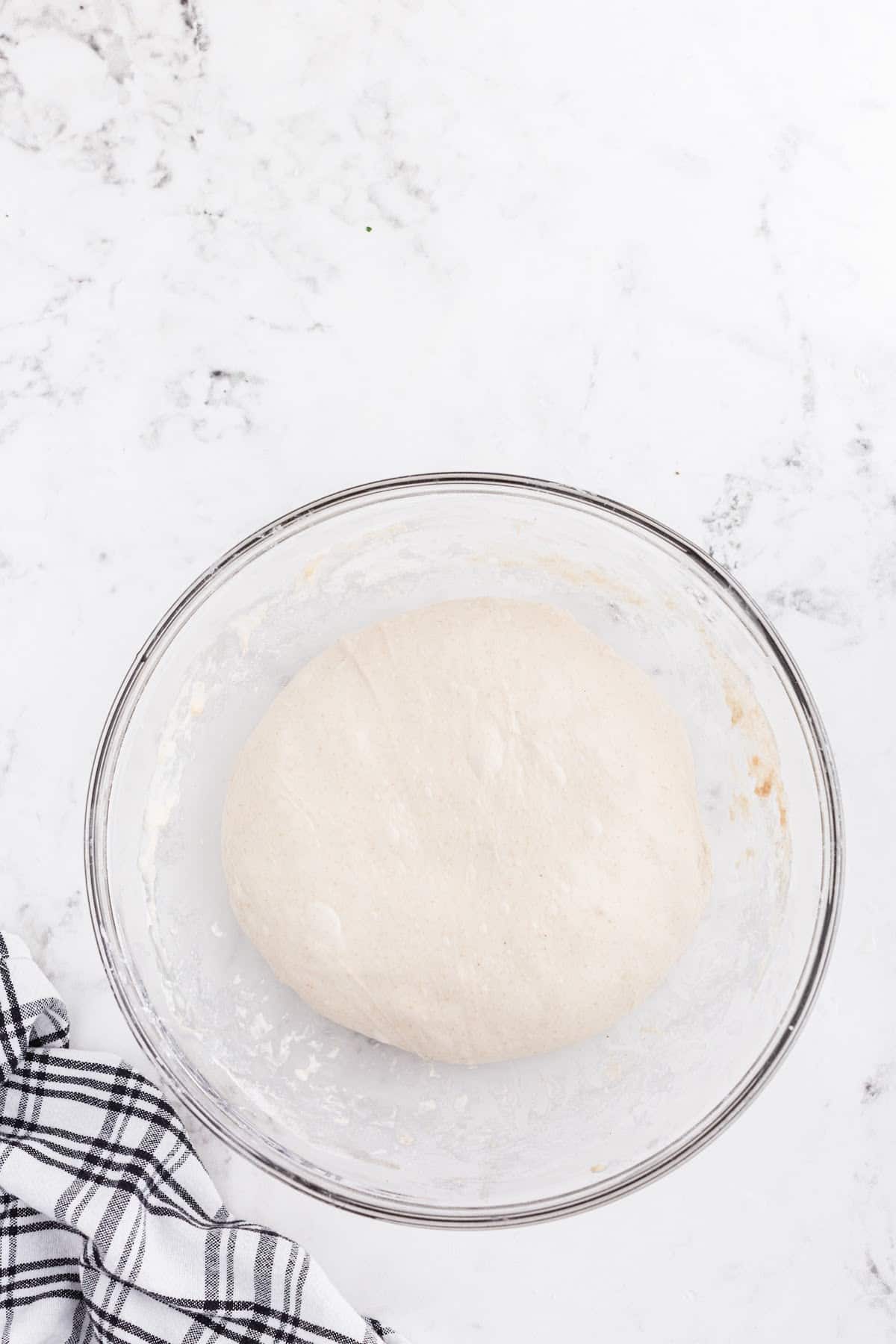 Smooth dough in glass bowl.
