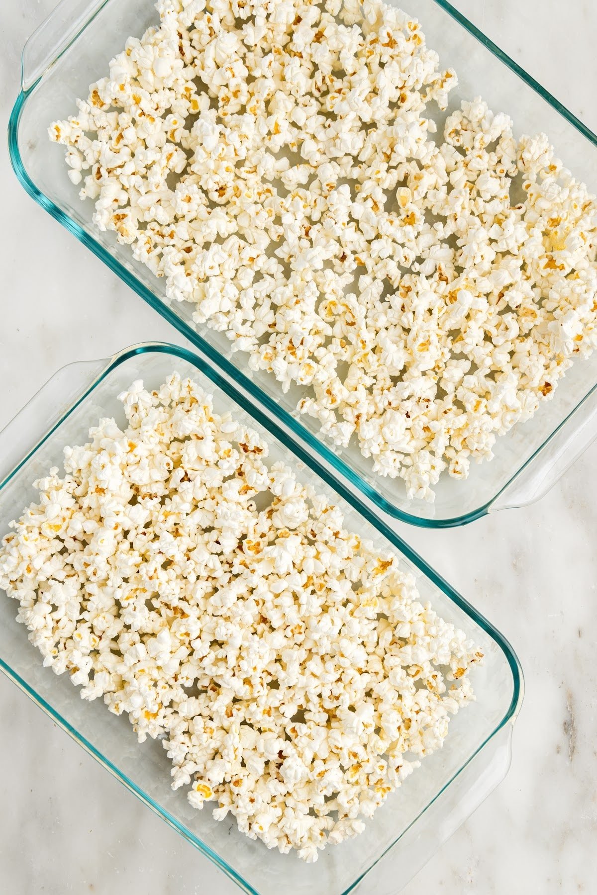 Two glass casserole dishes with dry popcorn.