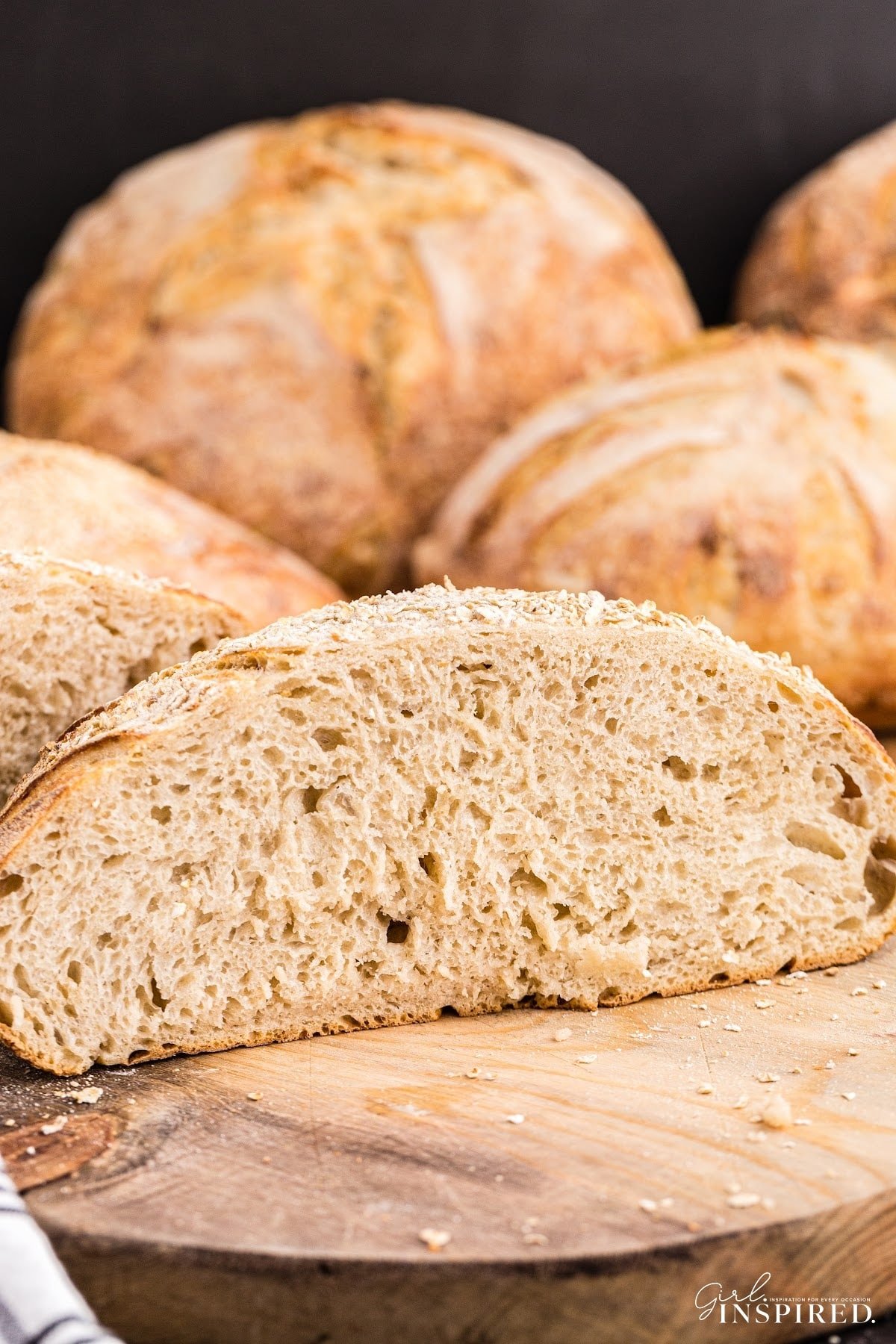 Sliced oat sourdough bread on a wooden kitchen board.