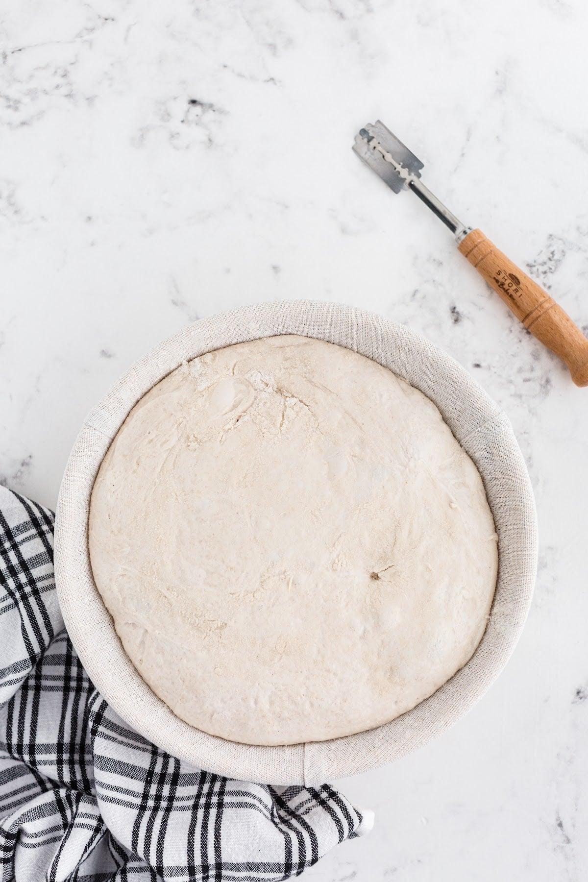 Chilled oat sourdough in the basket, ready to be transferred to a preheated Dutch oven for baking.