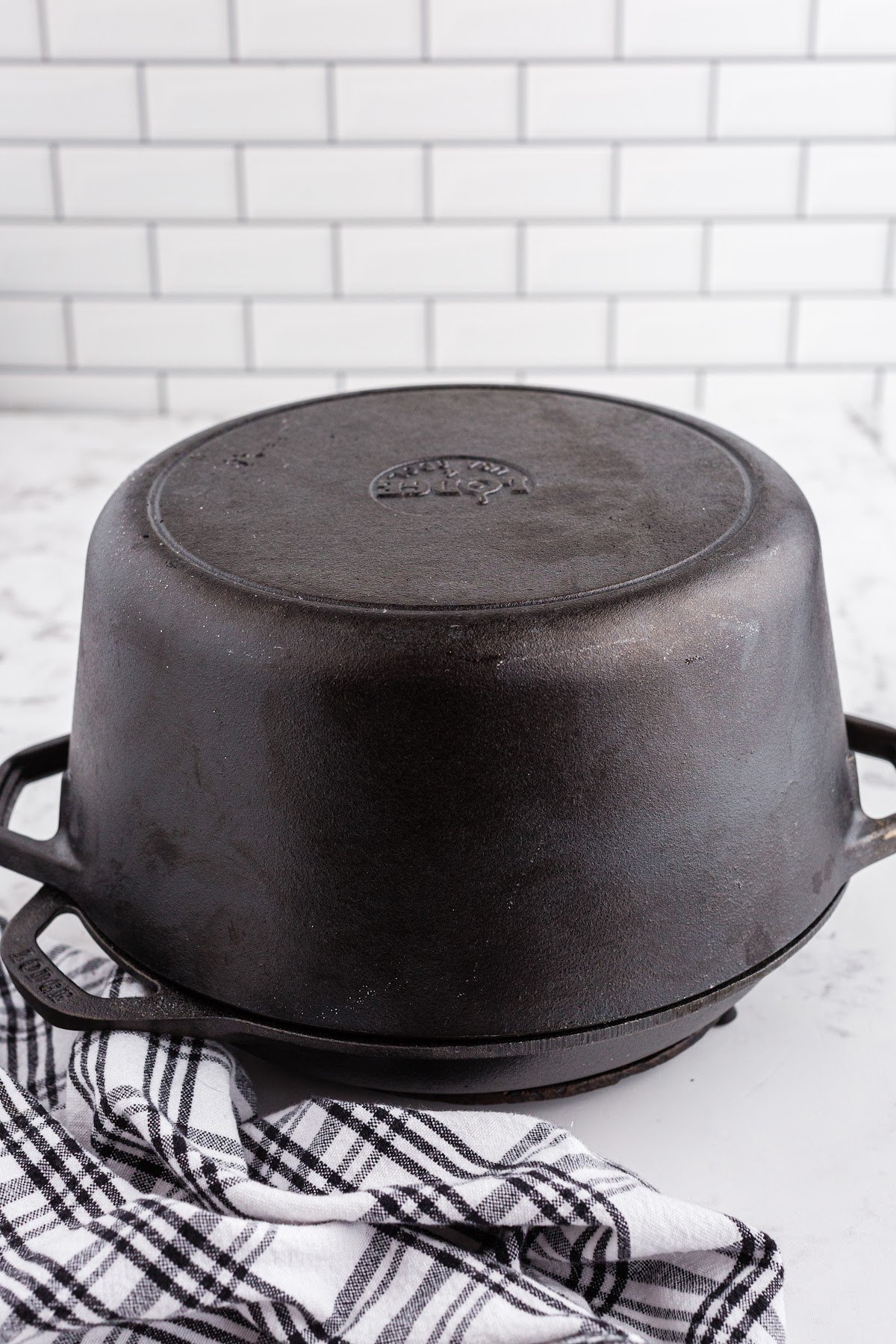Dutch oven removed from the oven with the baked oat sourdough loaf inside, ready to be removed and allowed to cool fully.