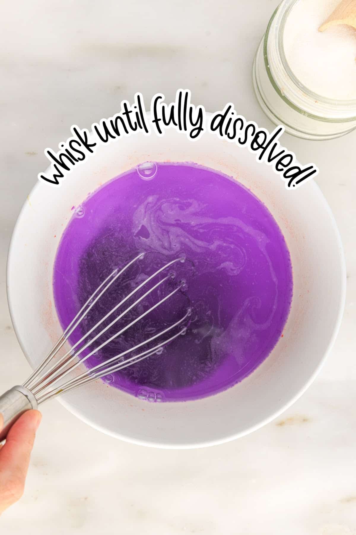 Dissolved purple jello in a bowl of boiling water with a whisk.