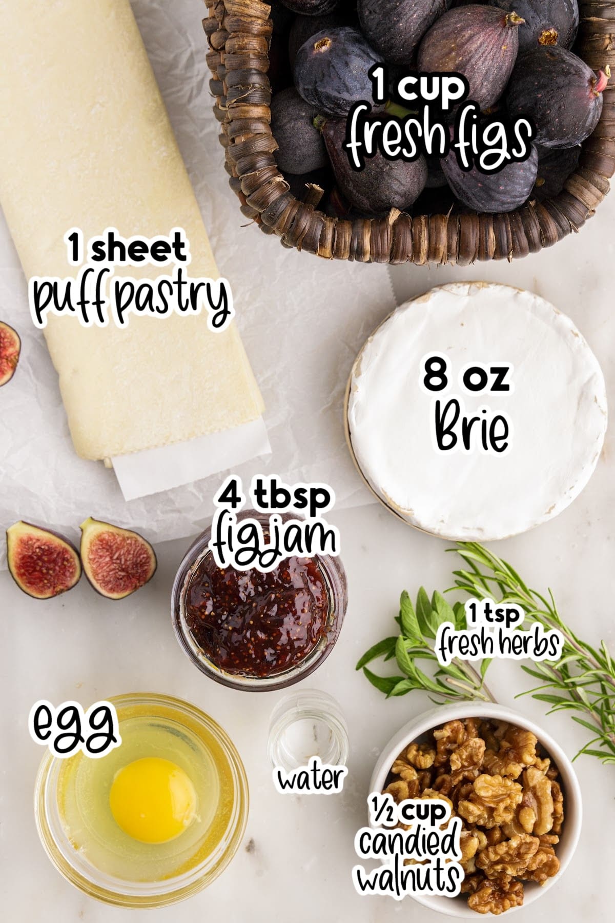 Ingredients for making baked brie with fig jam on a marble countertop.