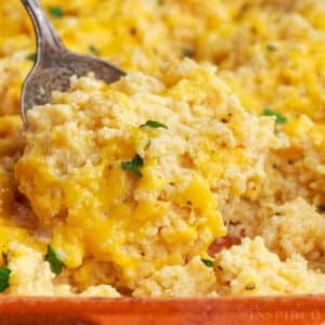 Serving spoon scooping up a portion of vegetarian rice casserole.