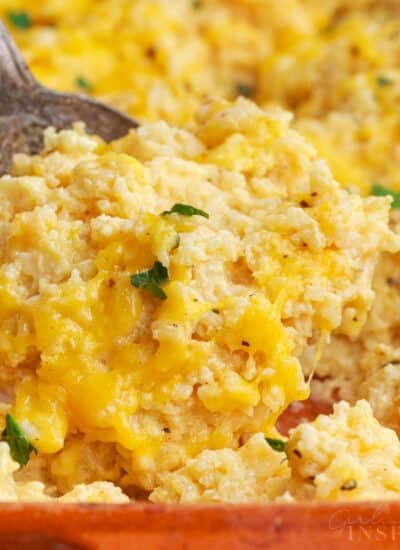 Serving spoon scooping up a portion of vegetarian rice casserole.