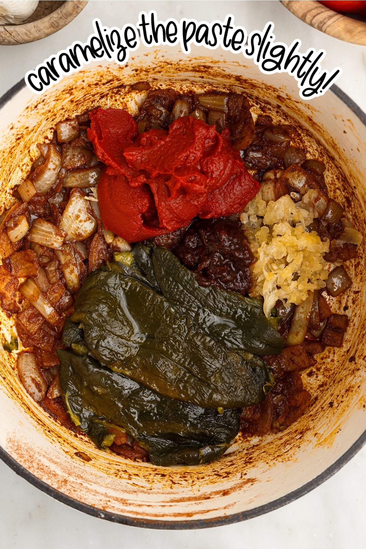 Garlic, chopped poblanos, tomato paste, and chipotle in adobo added to the softened onions and spices to make red enchilada sauce.