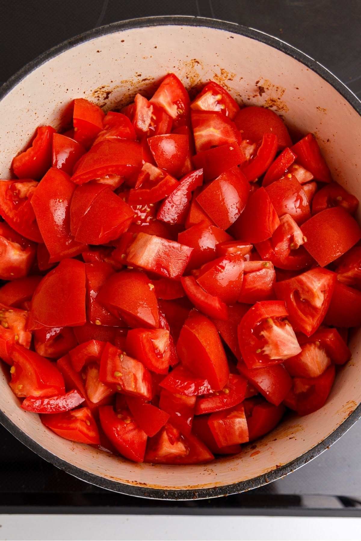 Chopped tomatoes and salt added to the red enchilada paste to simmer for making red enchilada sauce.