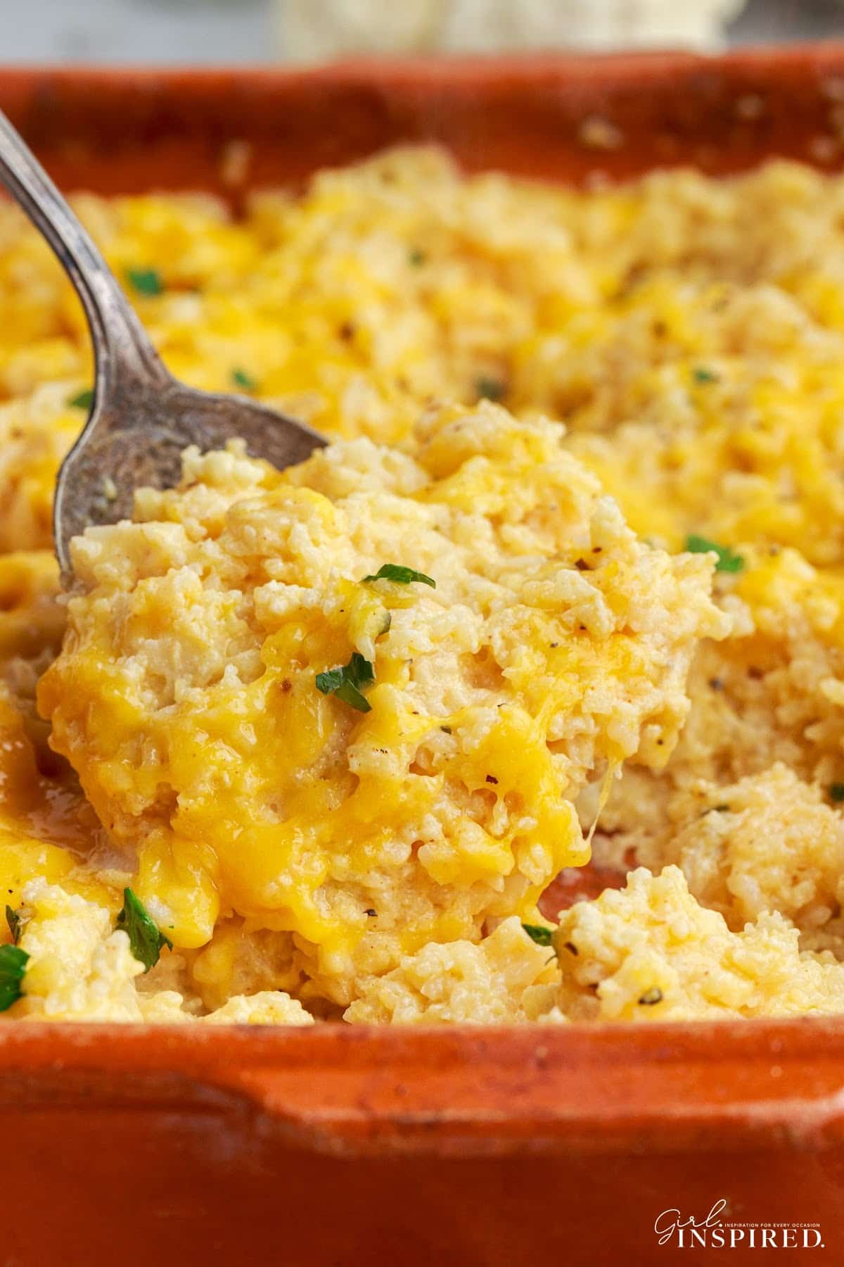 Serving spoon scooping up a portion of vegetarian rice casserole.