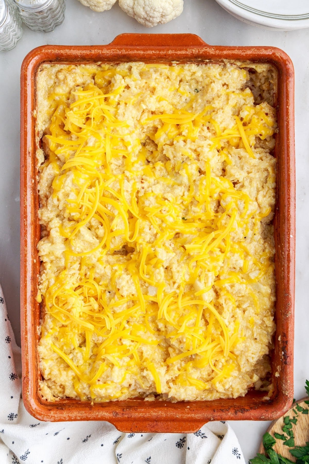 Par-baked vegetarian rice casserole topped with remaining shredded cheese.