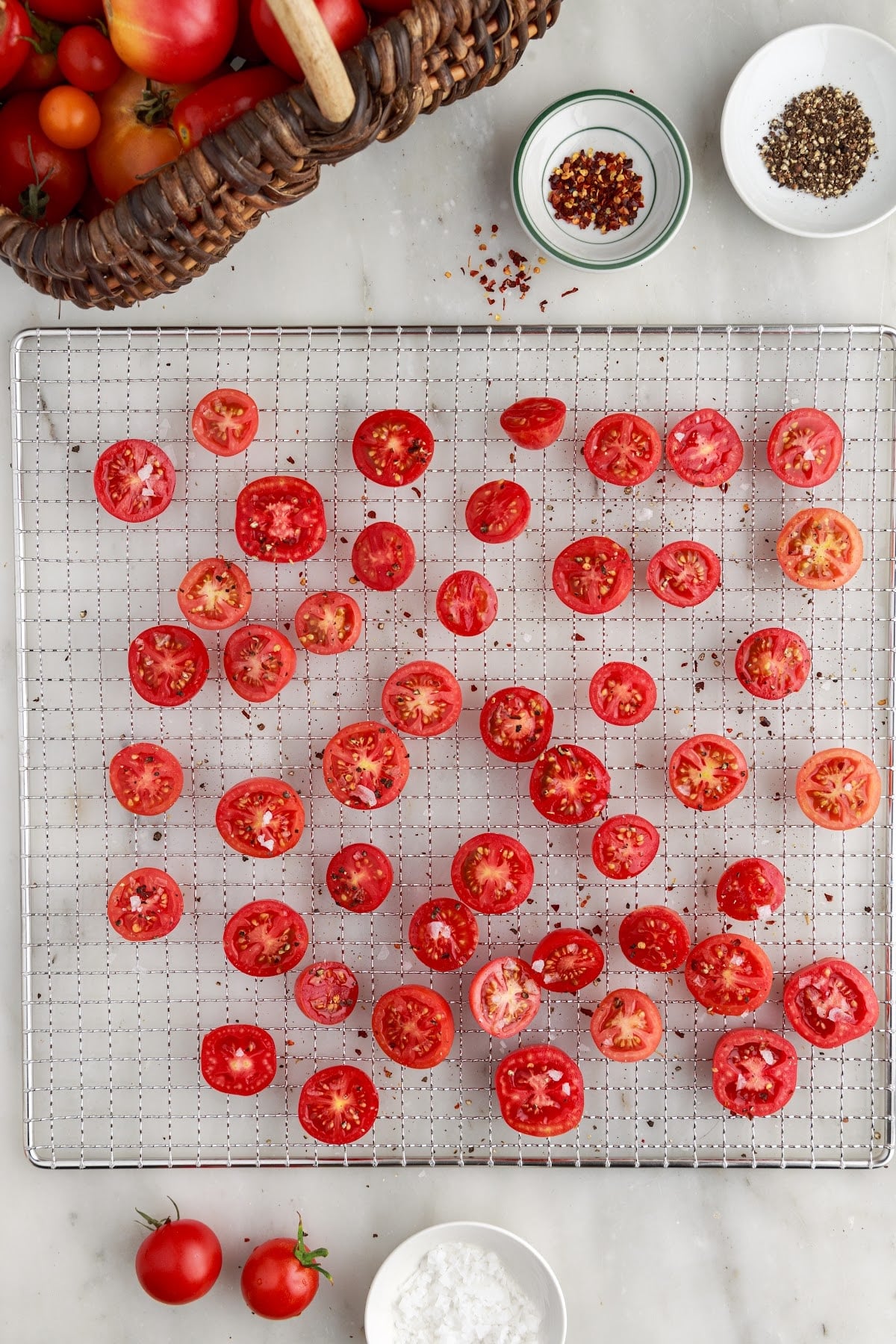 Sliced tomatoes arranged cut-side up in a single layer for dehydrating.
