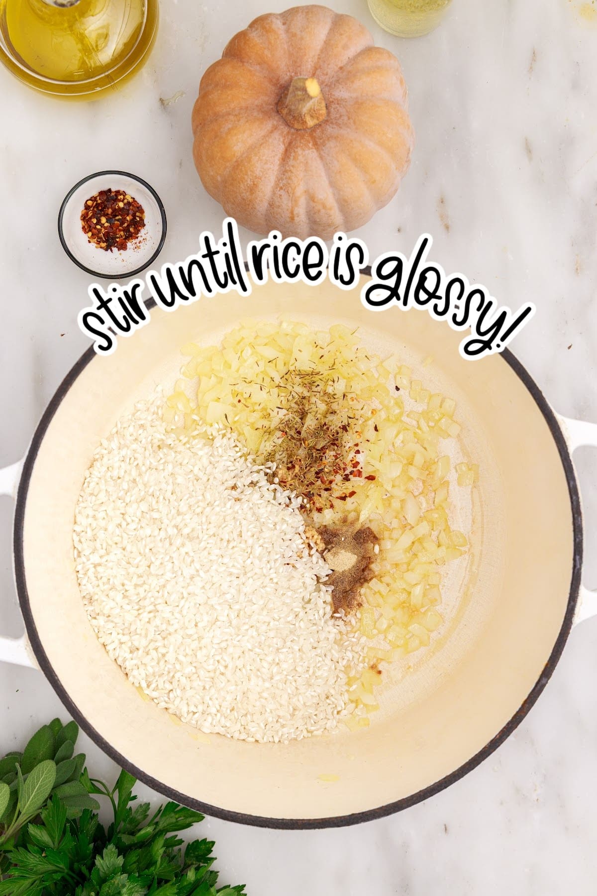 Rice, herbs, red pepper flakes, and white pepper added to a Dutch oven with softened onions for making baked pumpkin risotto. 