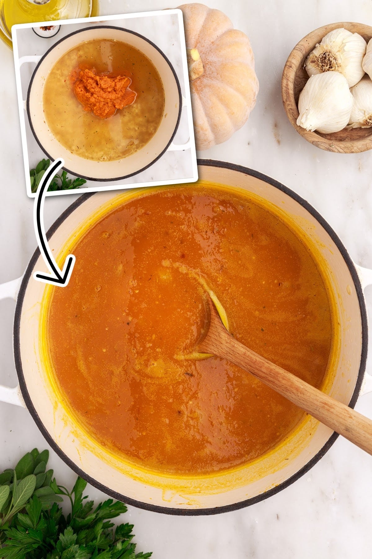 Pumpkin puree, chicken broth, and bay leaf added to the Dutch oven with other ingredients for making baked pumpkin risotto.